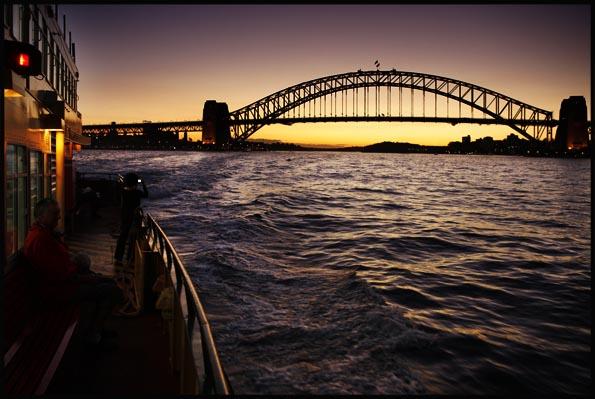 ferry approaching the Harbour Bridge at dusk
